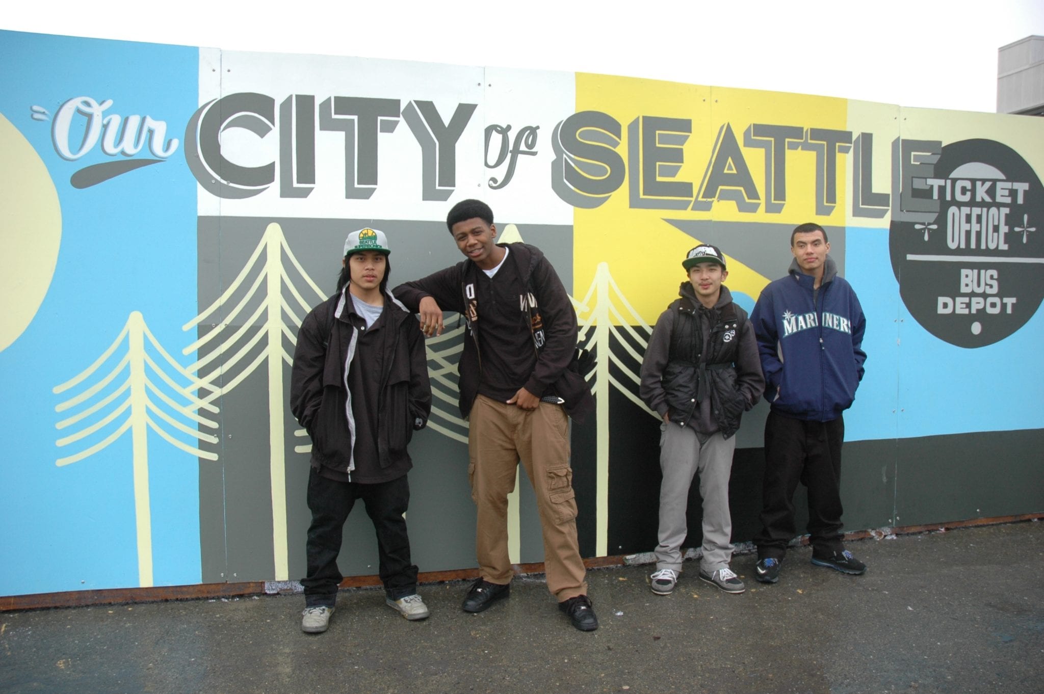 Participants in King County’s Education Employment Training Program pose in front of the mural they helped paint. Pictured left to right: Emmer, Justice, Leon and Randy. 