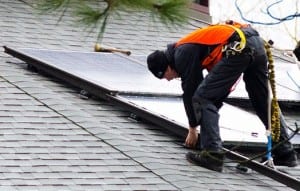 Photo of worker installing a solar panel.