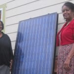 Photo of Clean Green employees with solar panel.