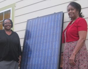 Photo of Clean Green employees with solar panel.