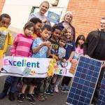 Photo of students and teachers with two solar panels.
