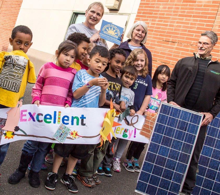 Photo of students and teachers with two solar panels.