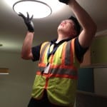Photo of man installing energy efficient light bulb.