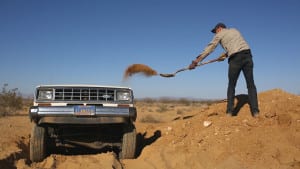 Photo of Sugarmann burying a Ford Bronco in the desert.