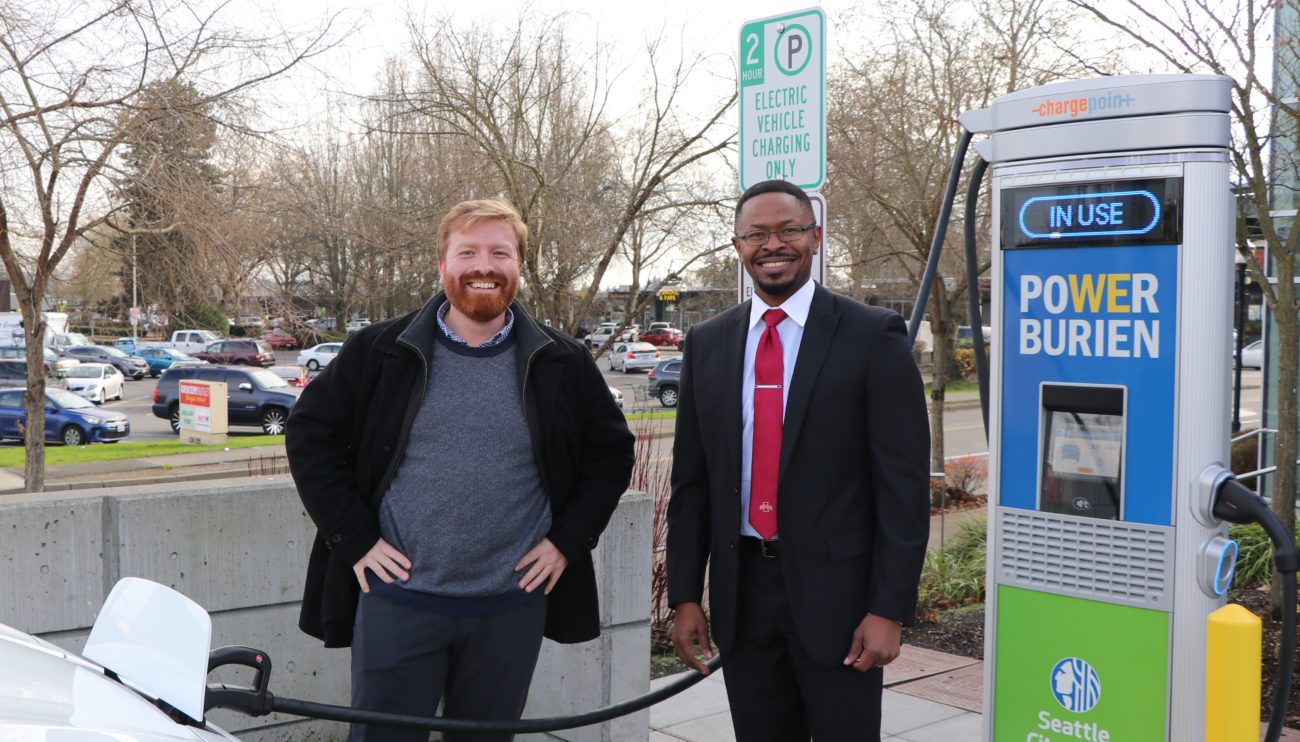 Burien City Councilmember Kevin Schilling and   City Light Energy Innovation Resources Officer Emeka Anywanu standing in front of the new electric vehicle charging station in Burien