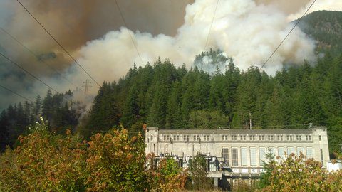 A wildfire burning on a mountainside about the Gorge Powerhouse at the Skagit Hydroelectric Project. 