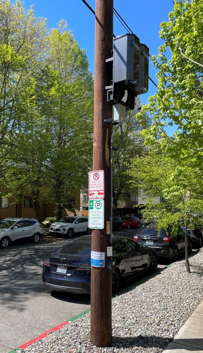 Wood pole mounted style Level 2 EV charger installed along the street curbside in a Seattle neighborhood.